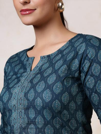 Preview: Detail view of the petrol blue tunic with leaf pattern - round neckline with small slit, trimmed with color-coordinated border.